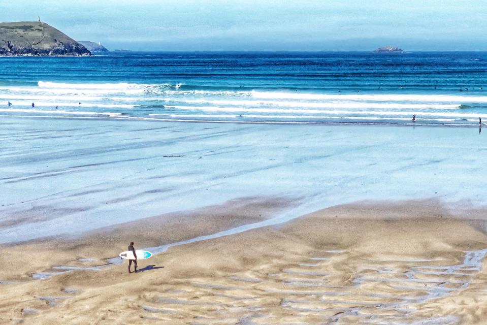  Lone surfer on an almost deserted Polzeath beach, Cornwall, this morning