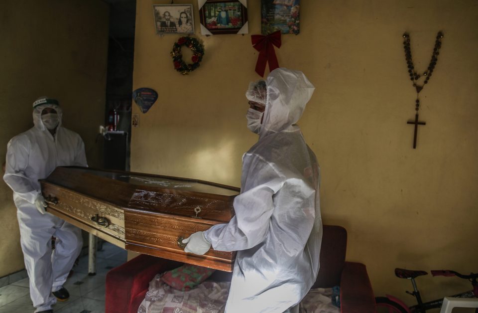  Officials in Manaus carry the coffin of a 60-year-old coronavirus victim