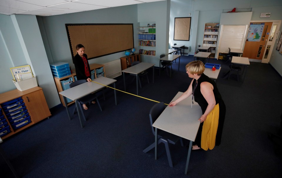  Teachers at St Anne's CE primary school in Sale, Greater Manchester, measure the distance between desks as they prepare to pupils to return