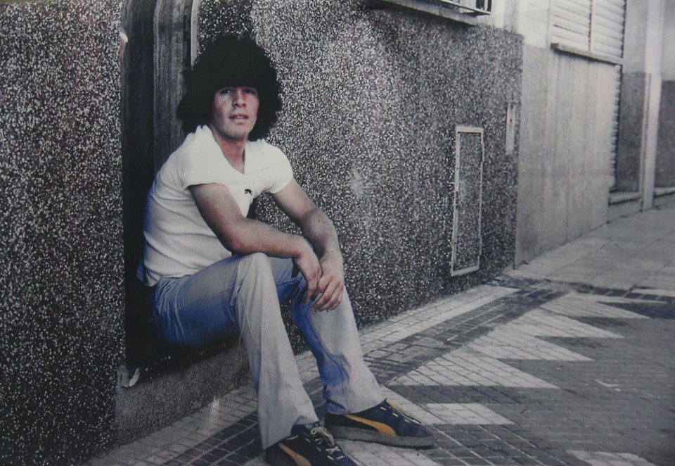 A teenage Maradona poses on the steps of his former home