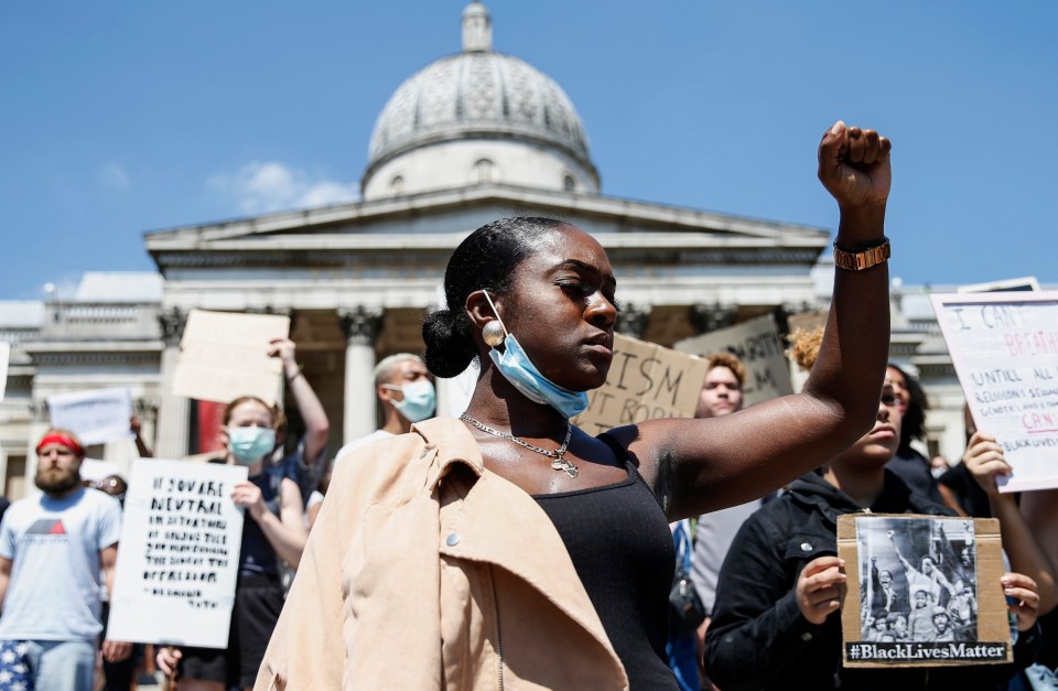 A woman holds her fist aloft as hundreds protested the death of George Floyd