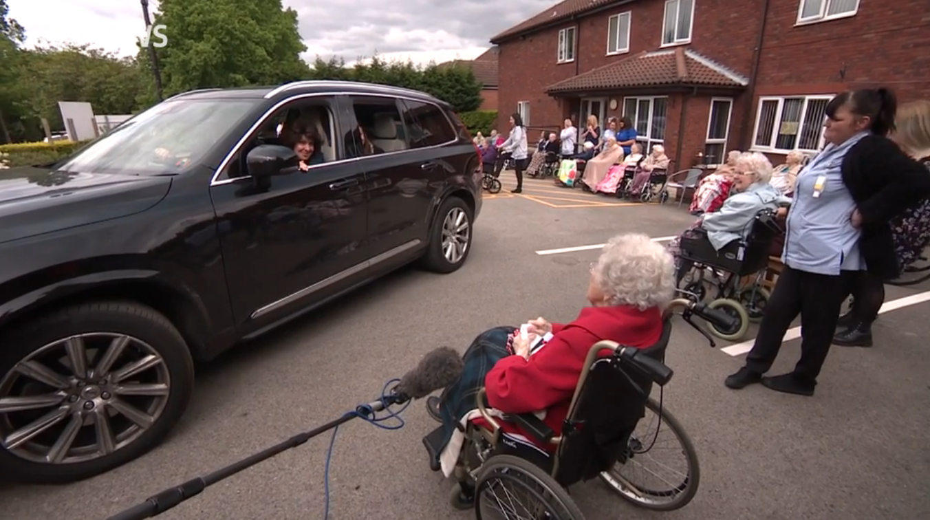  Residents sat outside the home as their relatives drove past