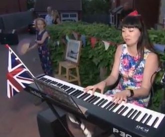  A woman plays piano to celebrate VE Day