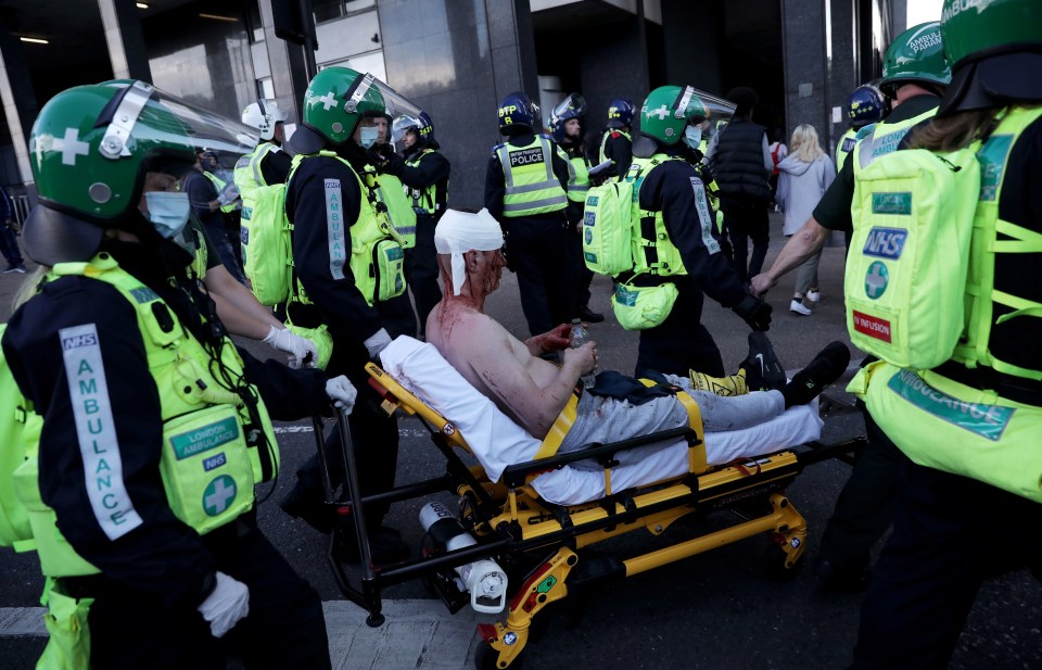 Medics in protective helmets treat an injured protester as the violence continued