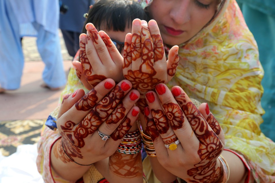 A Pakistani mother helps her daughter to pray during the Eid al-Adha holiday at a mosque in Lahore, Pakistan