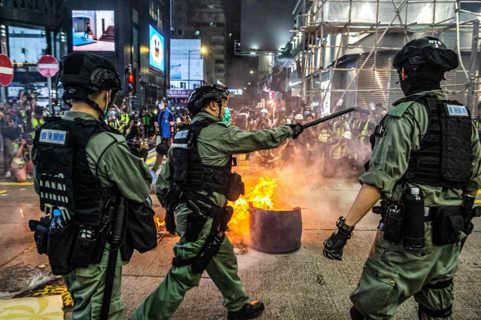  Police and pro-democracy protesters clash in Hong Kong as the city's legislature debates a law that bans insulting China's national anthem