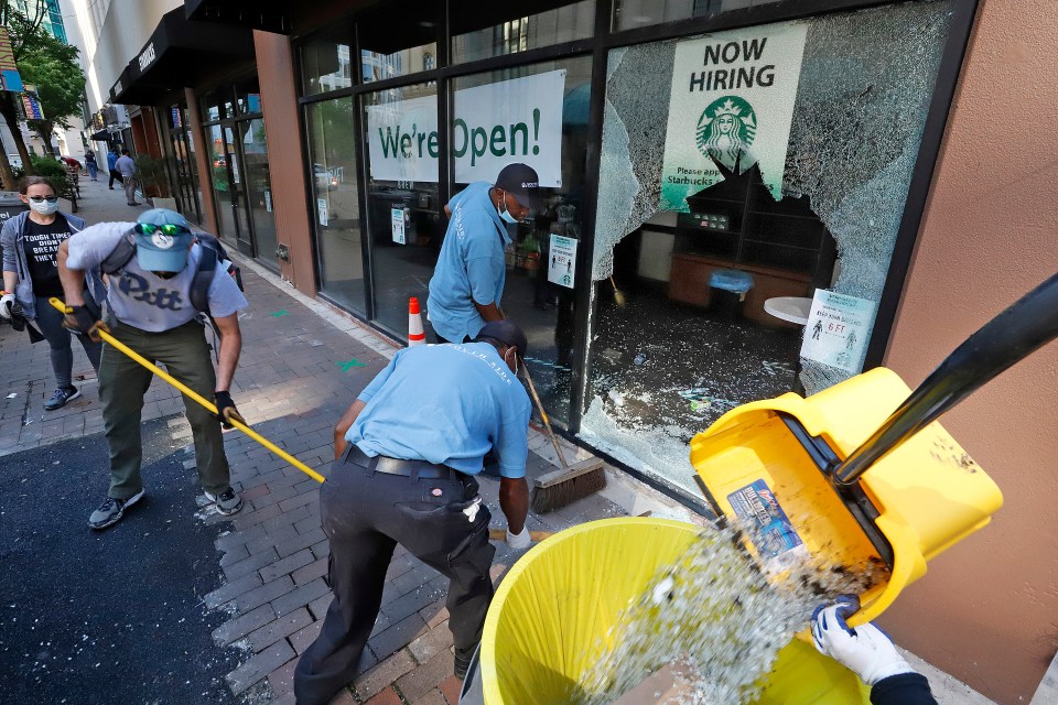 The glass from broken windows in a downtown Pittsburgh Starbucks store is cleaned up on Sunday, May 31