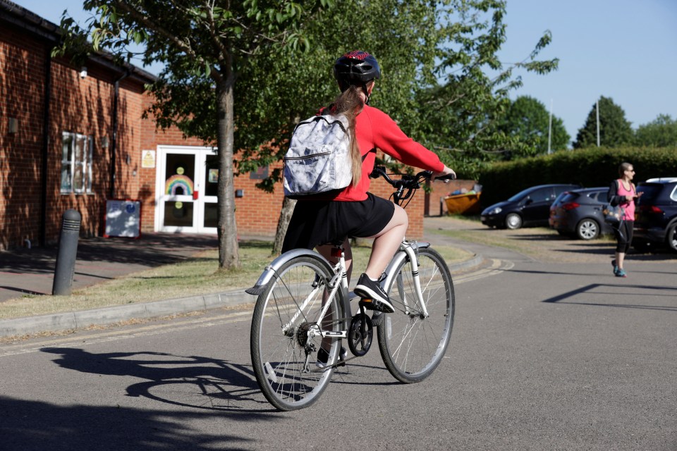  A young girl cycles to Watlington Primary school ready to get back to class