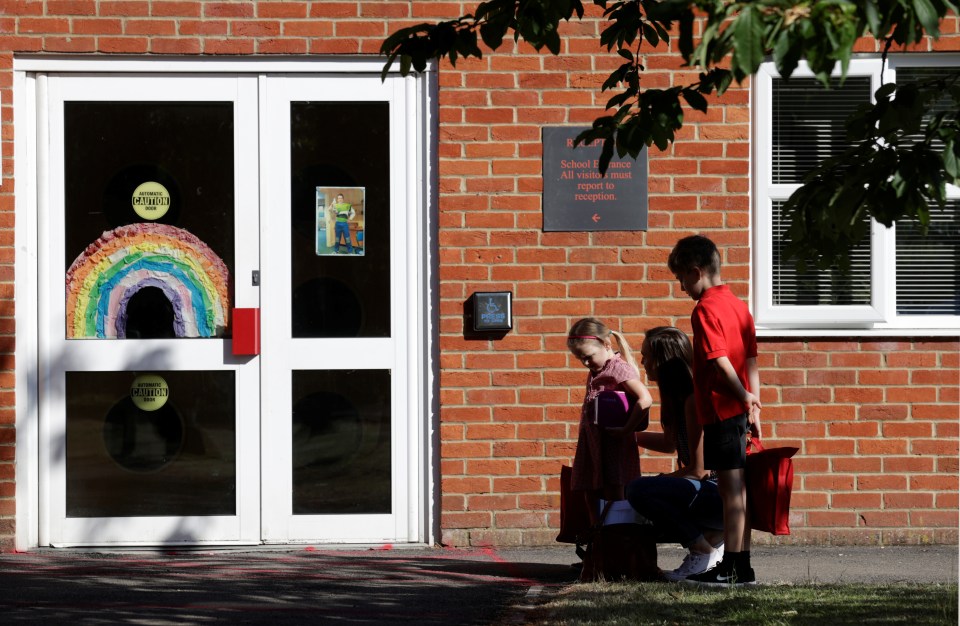  Students walk into doors covered with rainbows for the NHS for their first day back at Watlington Primary School in Norfolk