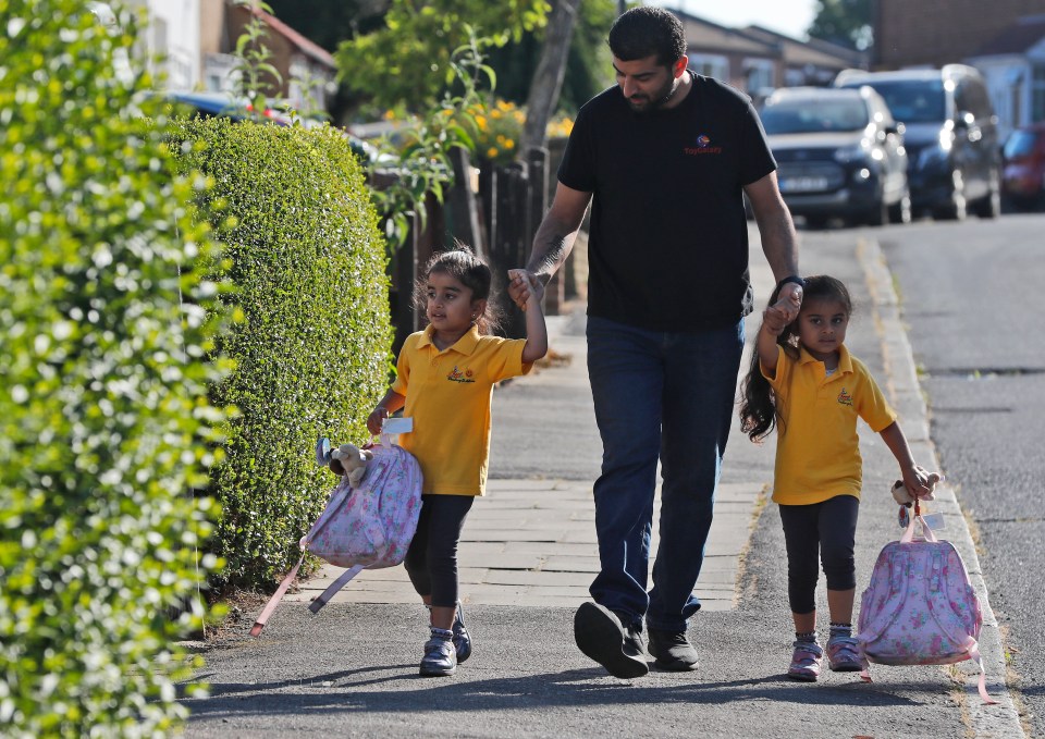  A father walks his twins to the Little Darling Childcare