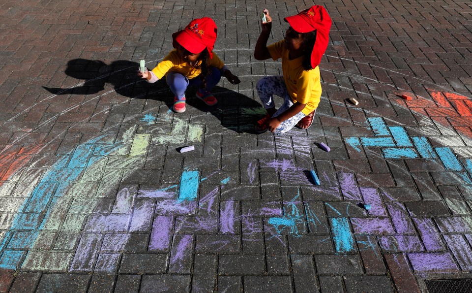  Excited kids draw a rainbow with chalk at the Little Darling home-based Childcare for their first day back