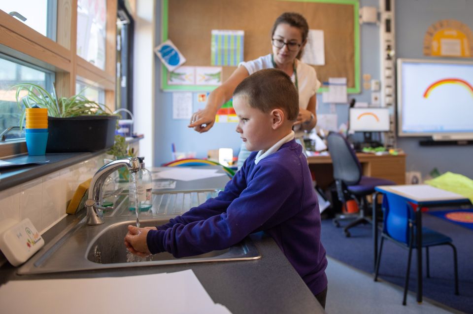  Reception pupil Braydon washes his hands whilst watching an electronic timer at Queen's Hill Primary School, Costessey, Norfolk