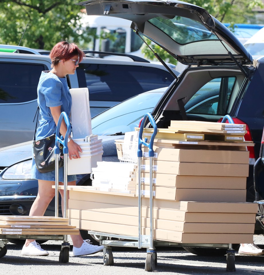 A woman loads her car boot