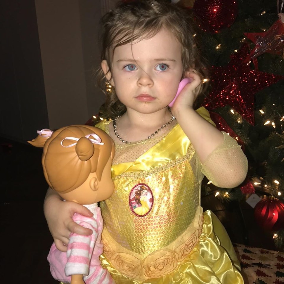 She clutched a doll while pretending to speak on the phone at Christmas time