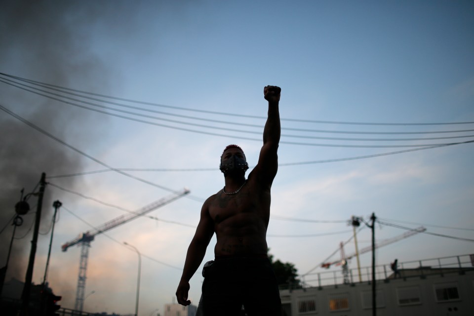  One man raises his fist to the sky as Paris erupts into violence