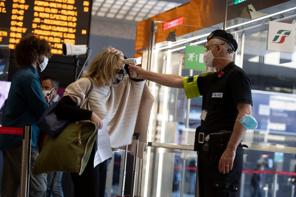  A passenger's body temperature is measured upon arrival at the Termini station