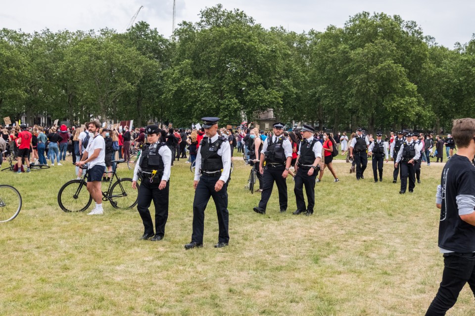  Police officers look on as protesters come together in Hyde Park, Central London in solidarity with the Black Lives Matter protesters in the USA