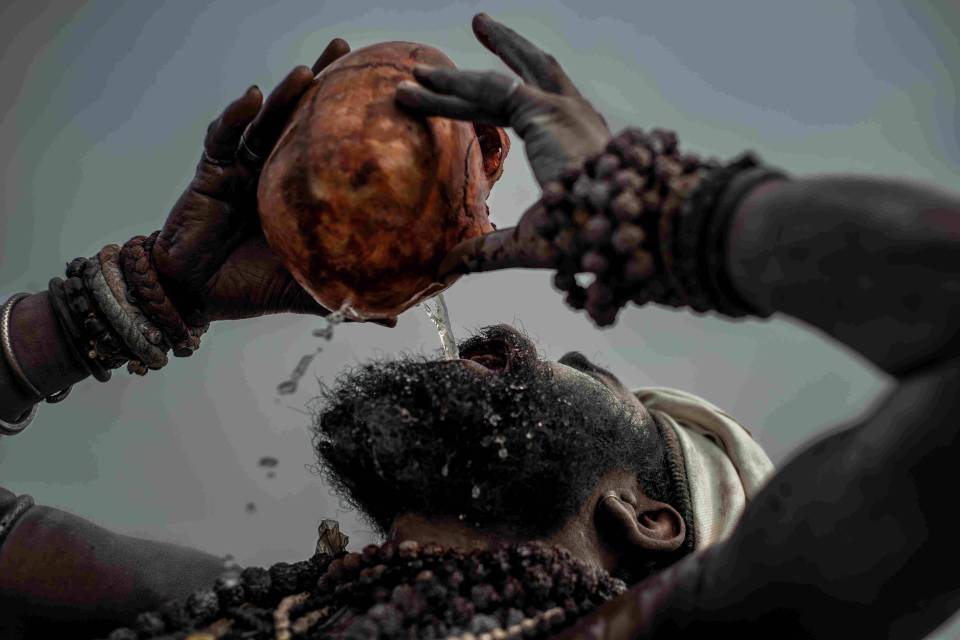  An Aghori man pours water into his mouth from a skull