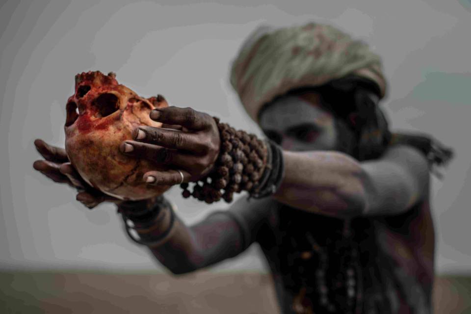  An upturned skull is held by an Aghori man