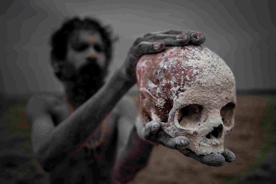  An Aghori man is pictured holding a skull between his hands