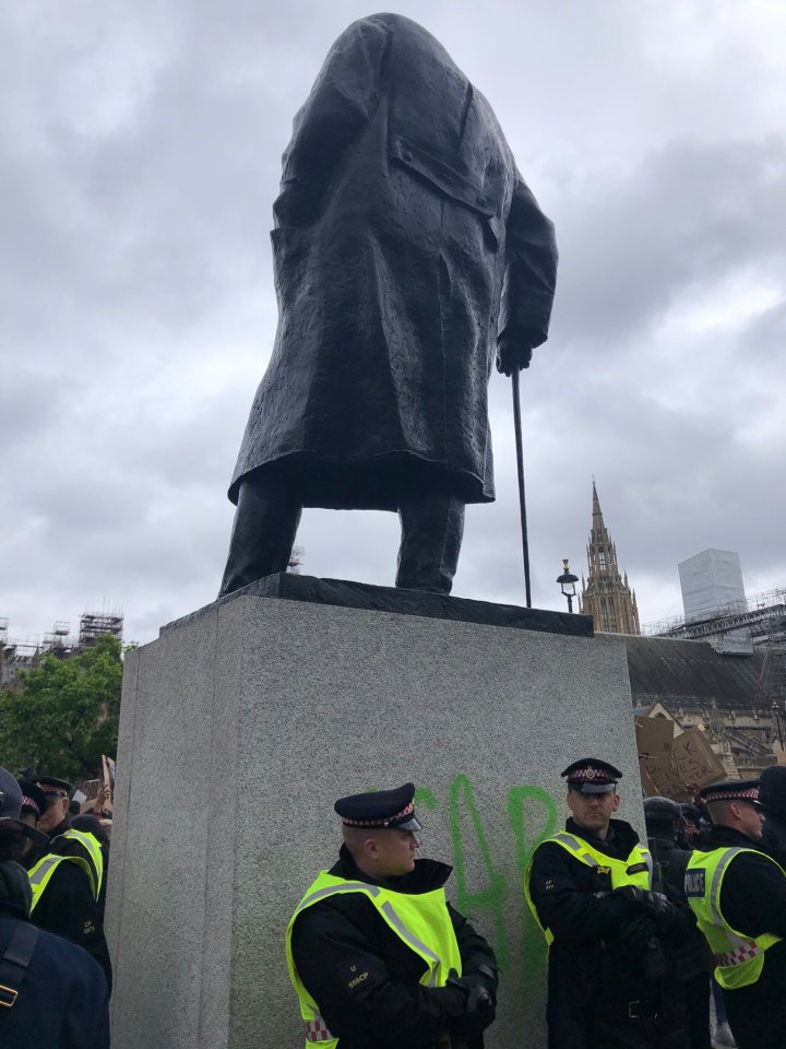 Police stand in front of the Winston Churchill statue after it was vandalised 