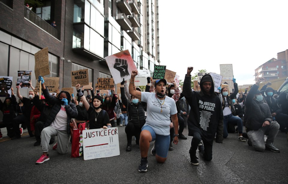 Protesters take a knee in solidarity with those who have accused the police of brutality and racism