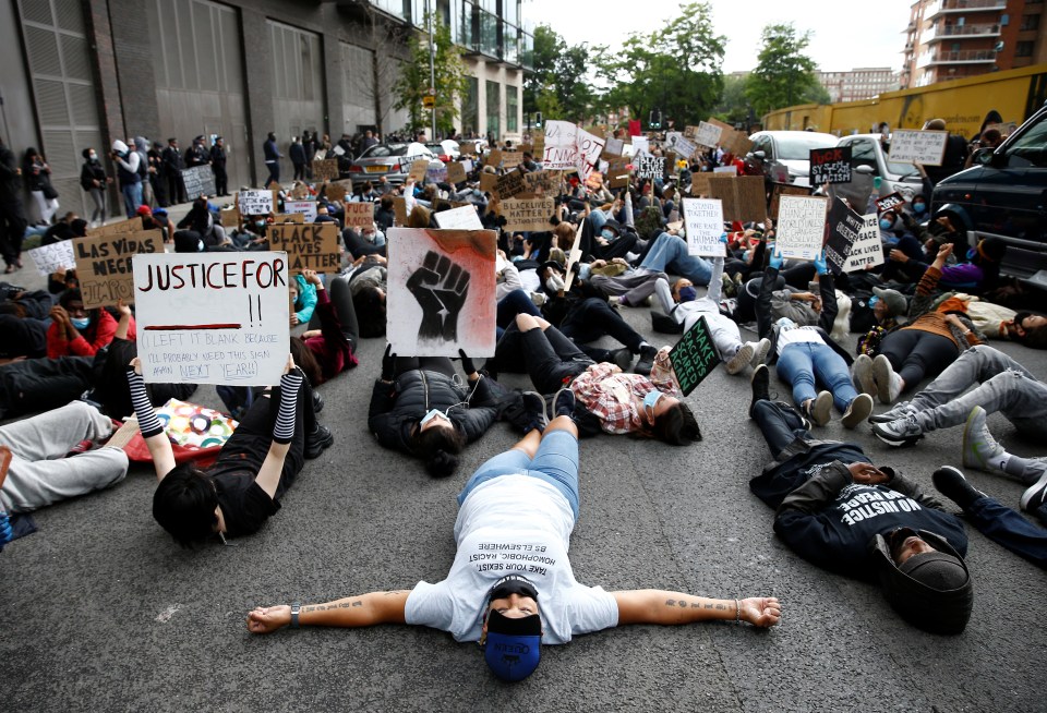 The demonstrators lie on the ground outside the embassy