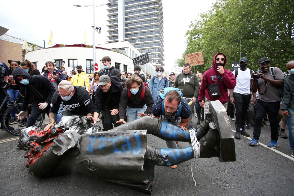 Protesters roll the statue of the slave trader towards the river