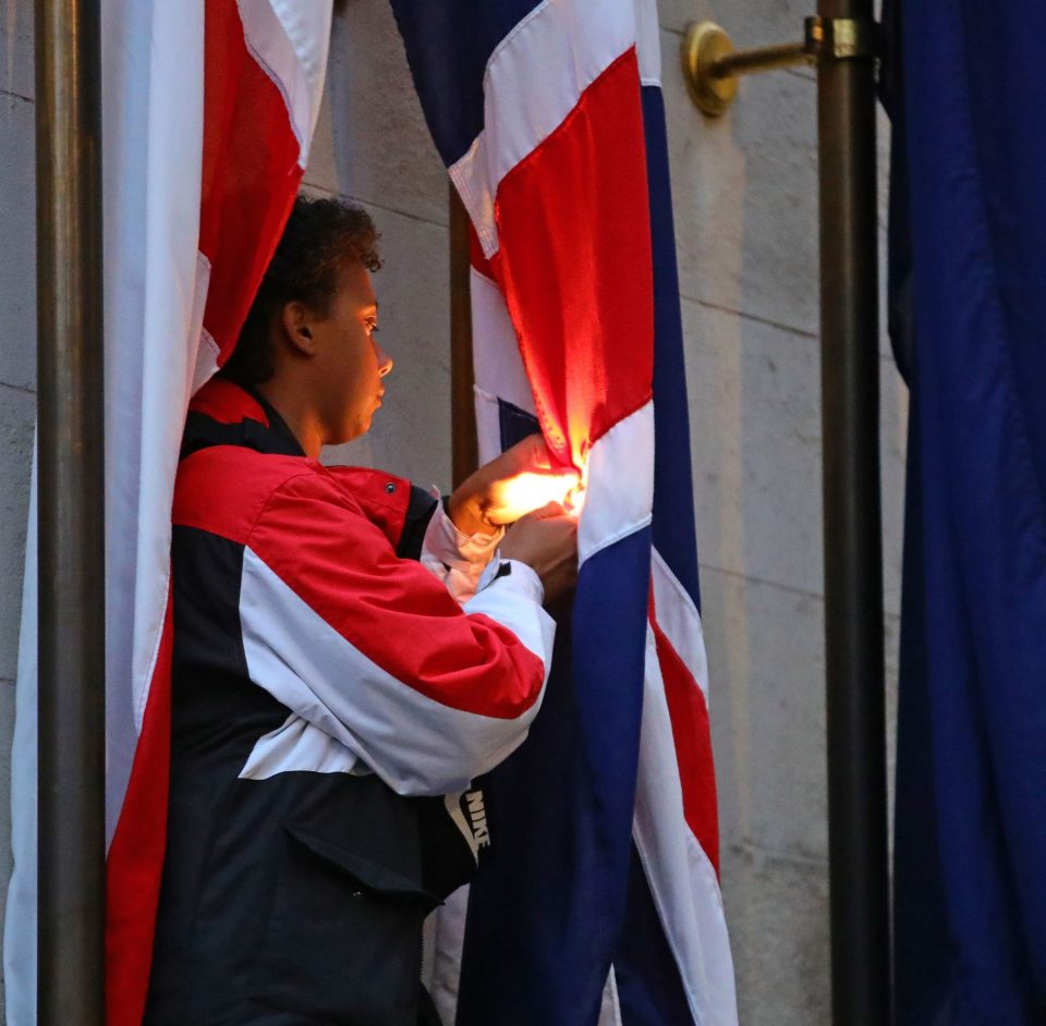 A protester uses a lighter as tries to set the flag on the Cenotaph on fire in Whitehall