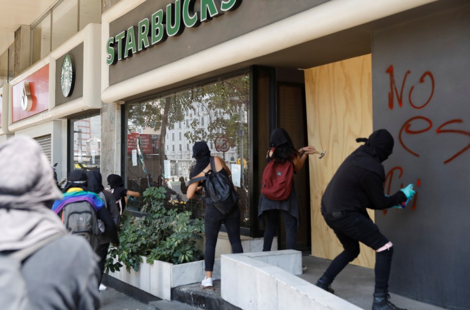 Demonstrators graffiti a Starbucks shopfront during a Black Lives Matter protest in Mexico, in Mexico City