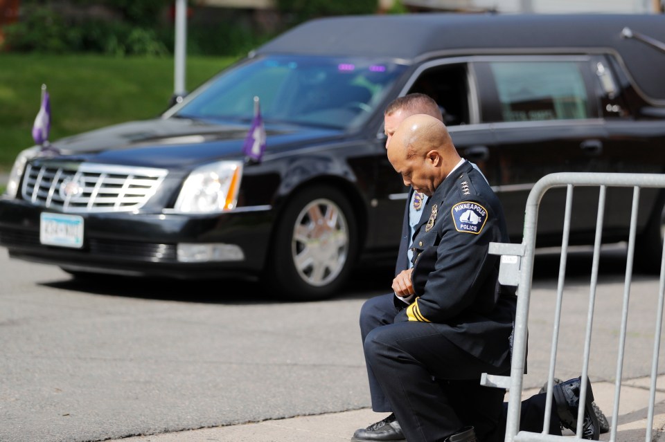  Police officers take a knee as the body of George Floyd arrives before his memorial services in Minneapolis