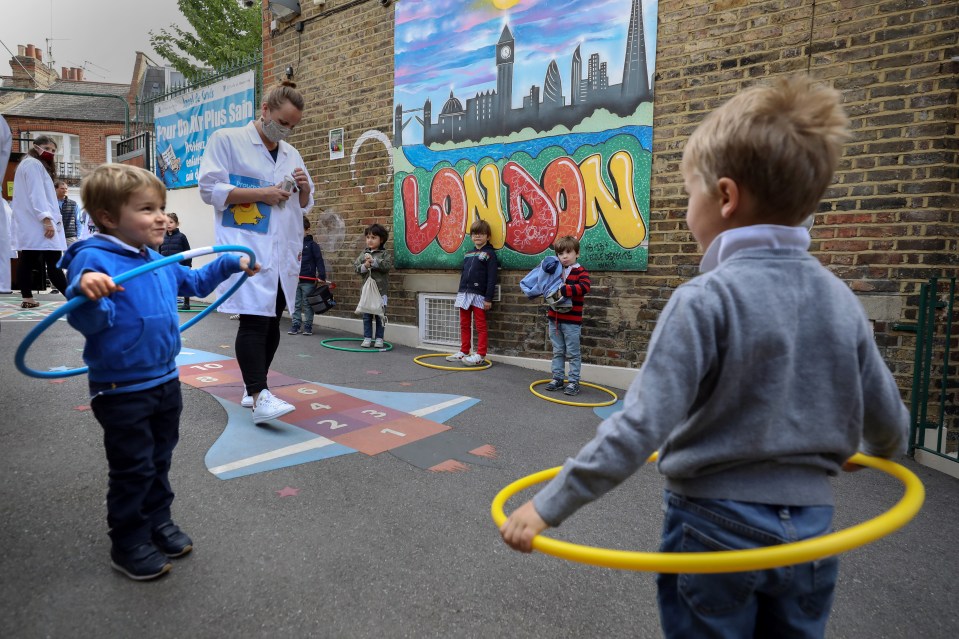 Children use hoops for social distancing at L'Ecole Des Petits school