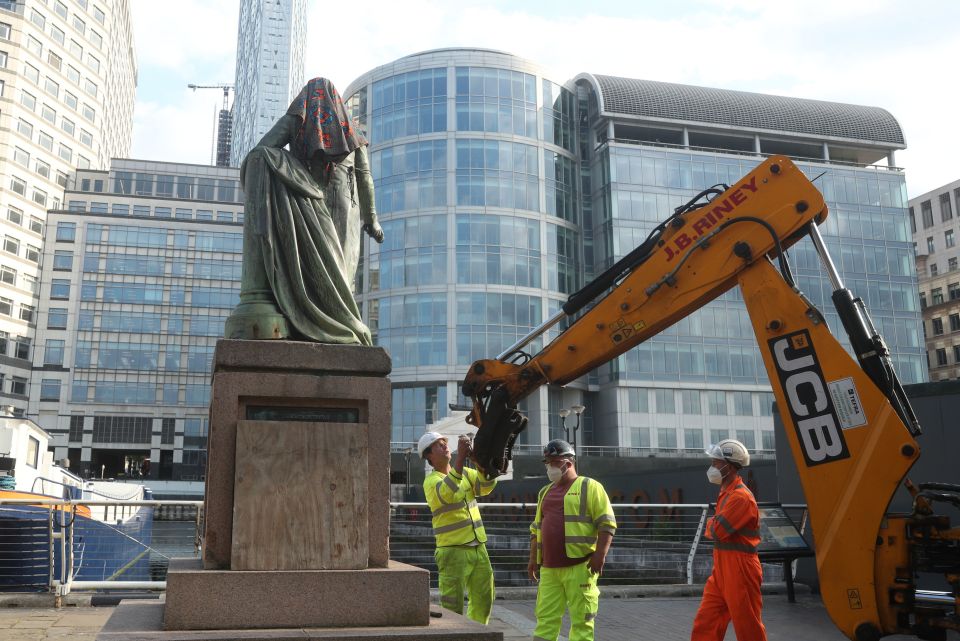 Workers prepare to take down a statue of slave owner Robert Milligan at West India Quay, east London 