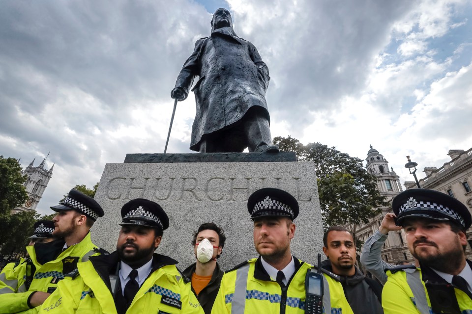 Police officers protect the Churchill statue from being vandalised during protests