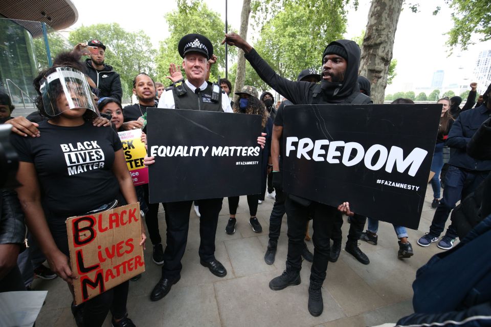 A police officer holds up a sign outside New Scotland Yard