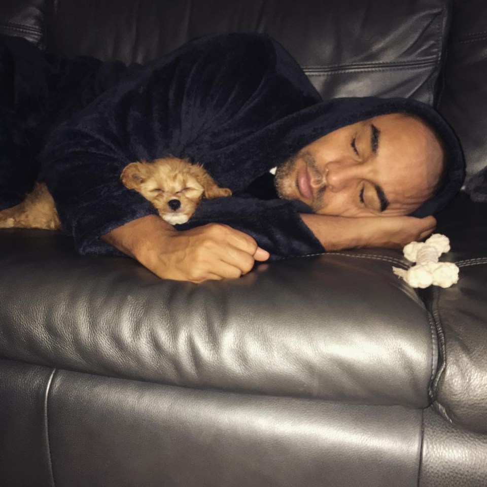 Alex snuggled up to his dog on the brown leather couch