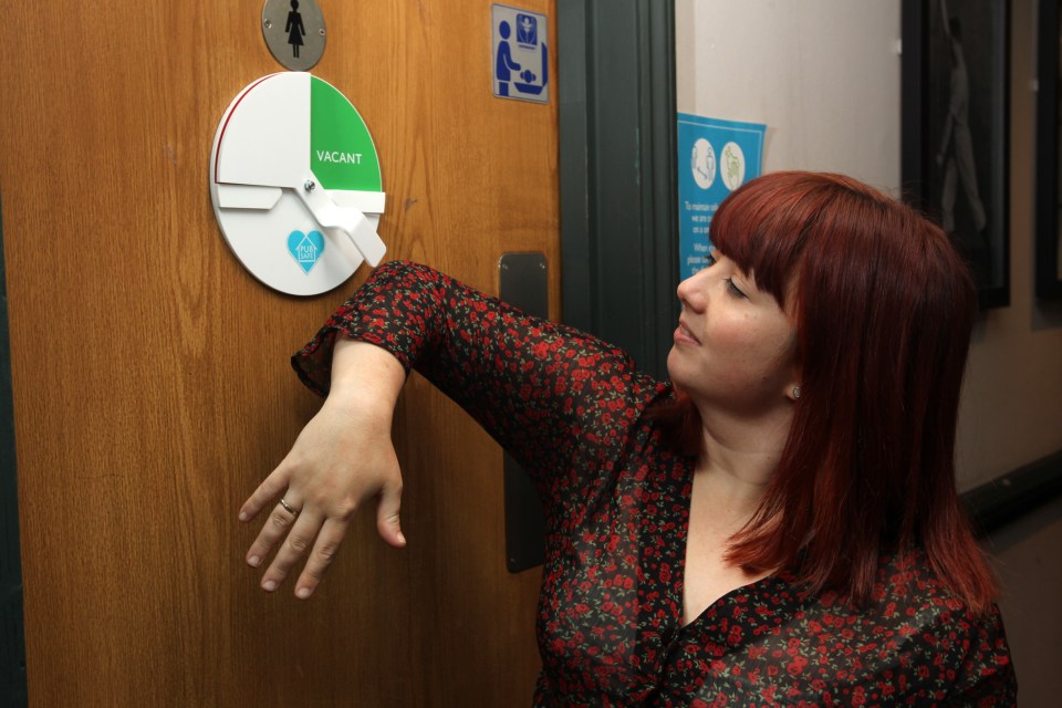 The Sun reporter Levi Winchester uses her elbow to move the one-in-one-out toilet indicator at the Greene King pub 