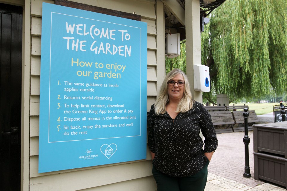 Sheree Thomas, general manager at the Green King Pub, Fort St George, stands next to the list of new pub garden rules