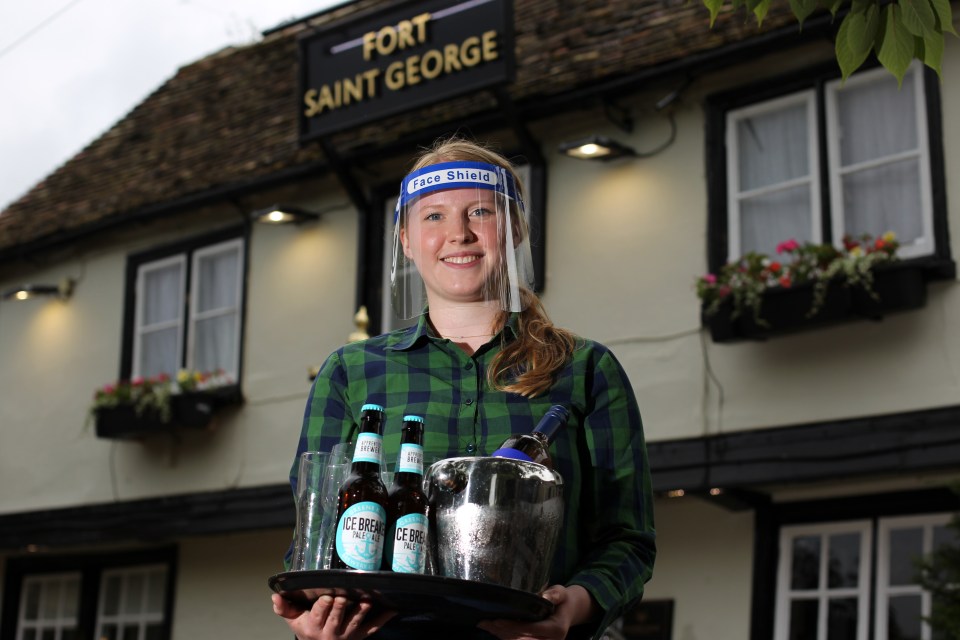 Elizabeth Harper, Assistant Manager at a Greene King pub wears a face shield while serving customers