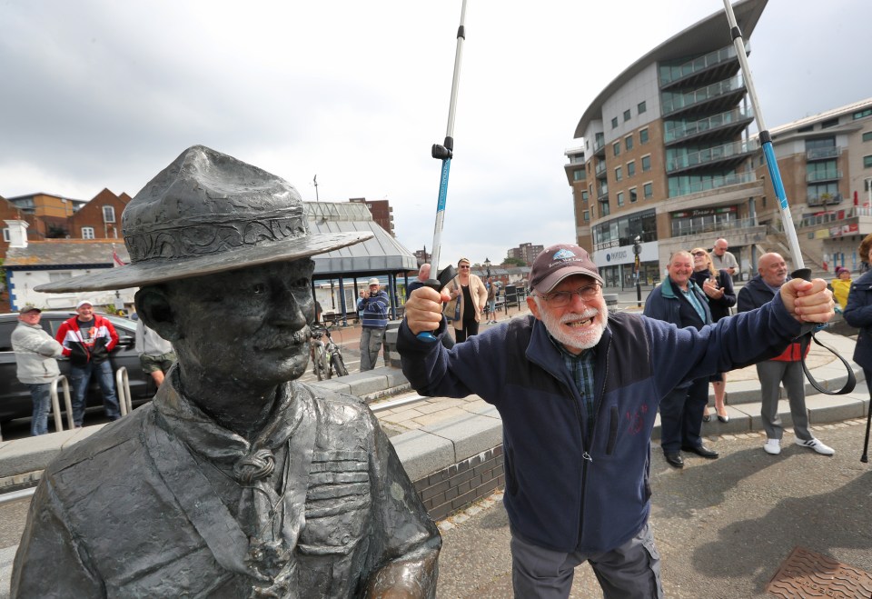 Former Boy Scout Len Banister, 79, lifted his walking sticks in the air as he stood in front of the statue