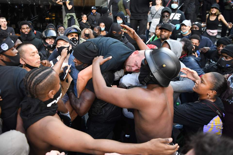 A brave member of BLM carries a man from the counter protest to safety after he was punched