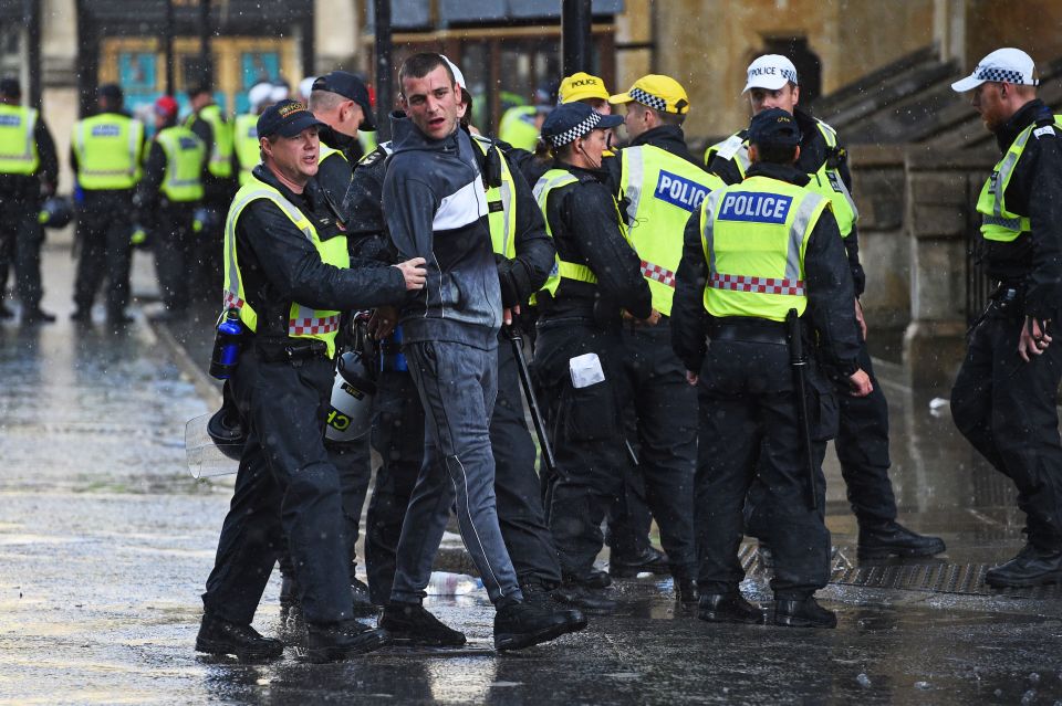 A man is led away by police in central London after protest groups clashed