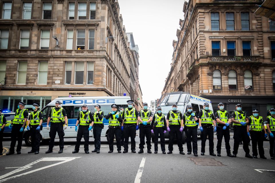  Police officers line a street in Glasgow amid protests in the city