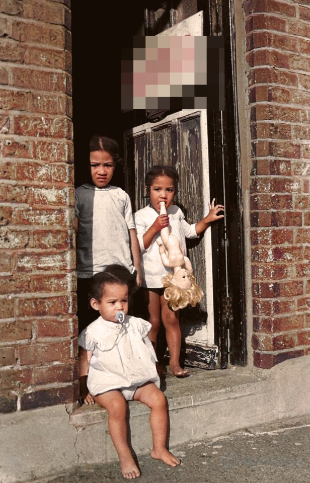 A house firebombed by far-right white supremacists the National Front had the racist term "W**s" scrawled over the door as three children stand beneath