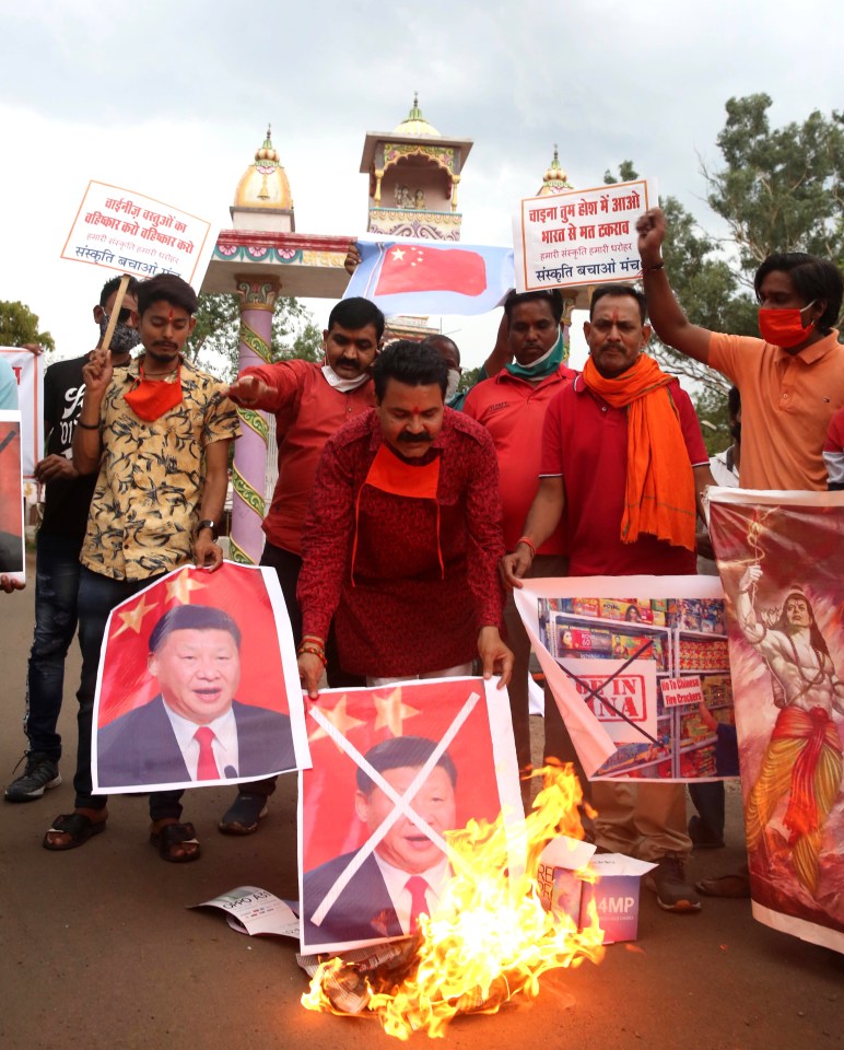 Indians protestors hold up pictures of Chinese president Xi Jinping