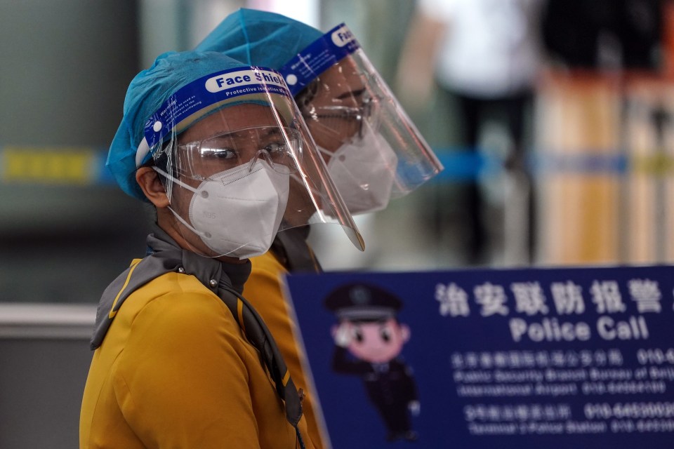 Staff wearing protective face masks at terminal 3 of Beijing Capital International Airport