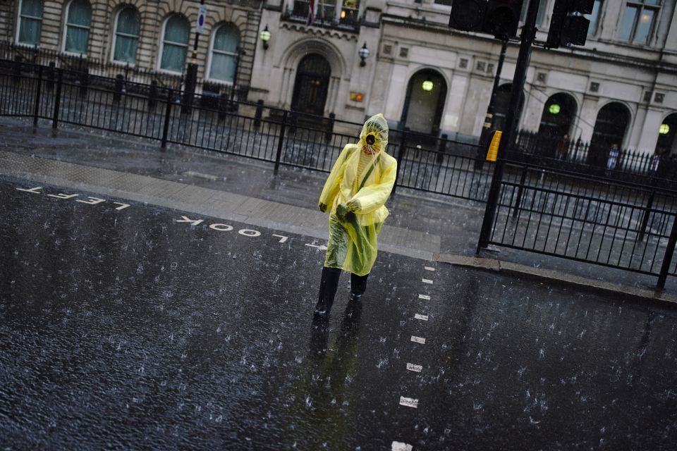  A woman walks through heavy rain in London as violent thunderstorms sweep Britain