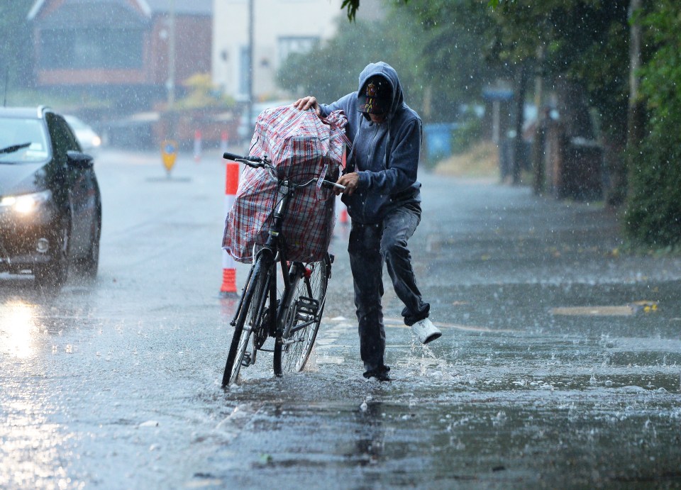  A cyclist tries to walk through flooded streets in Leicester