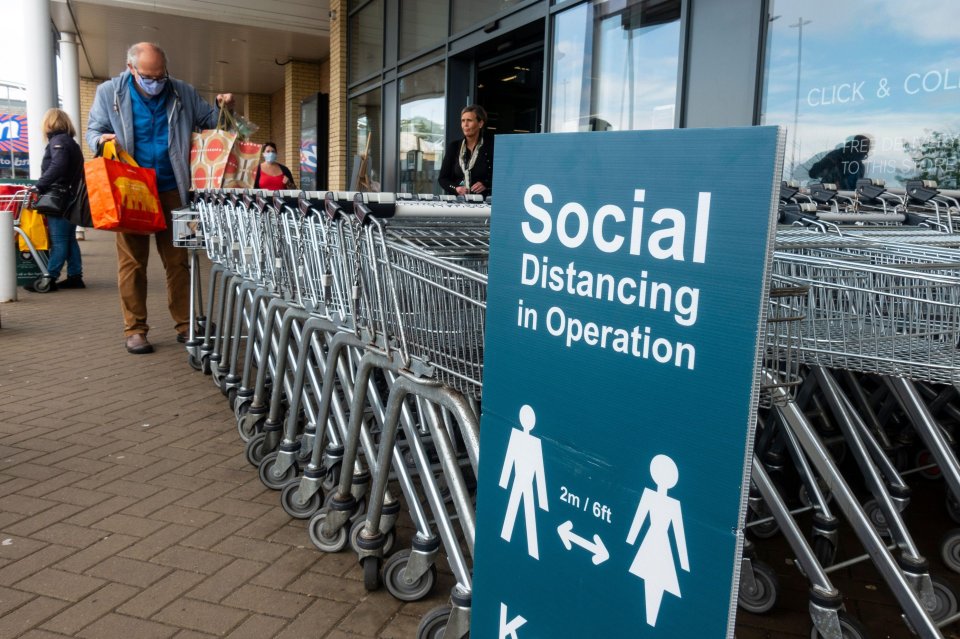 Signage warning customers to maintain 2m social distancing is positioned outside and inside shops 