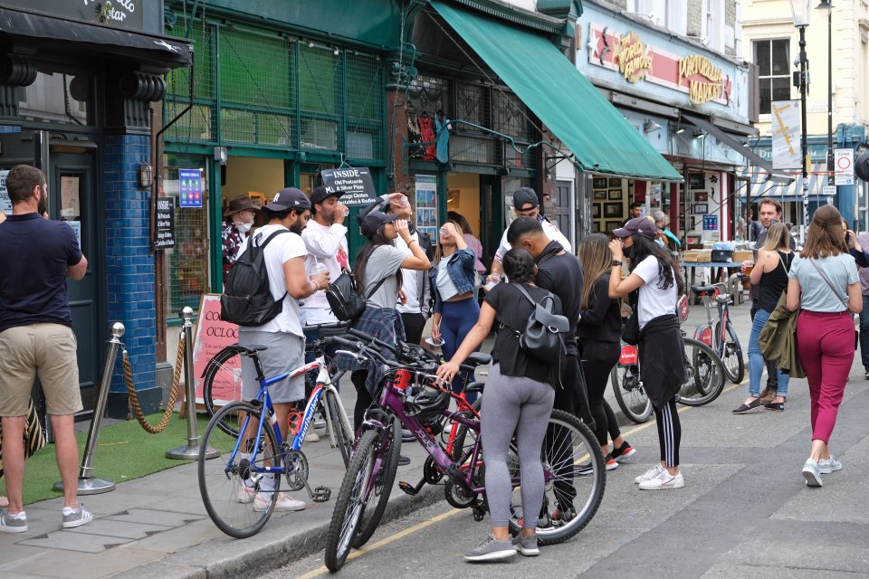 Some people were seen with masks on as they stood outside London pubs